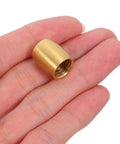 Close-up of a single brass cone-shaped foot from the 8pc Brass Furniture Legs For Wooden Trays And Boxes, shown on a hand