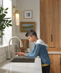 Heavy Duty Stainless Steel Water Dispenser Faucet Built Tough For Reverse Osmosis Systems Featuring Rust Resistant Finish and Slick High Flow Pour For Your Kitchen Setup in modern kitchen with child pouring water.