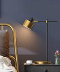 Mid Century Modern Desk Lamp with Matte Black Finish and Gold Accent on bedside table, 22.25 inch tall, in bedroom setting.