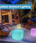 16-Inch Cordless LED Cube Light With Removable Panels illuminating outdoor patio at night, creating vibrant ambiance.