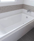 Slick Chrome Finish 27 Inch Cable Driven Bathtub Drain Trim Kit With Smooth Pop Up Stopper And Rotating Overflow Cover Brass Knob installed in a modern bathtub.