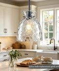 7.5" Black Hammered Glass Pendant Lights Kitchen Island Lighting 1 Pack E26 hanging over a kitchen island with a bright bulb.