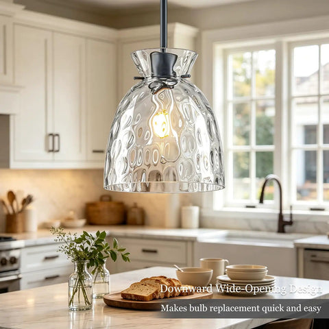 7.5" Black Hammered Glass Pendant Lights Kitchen Island Lighting 1 Pack E26 hanging over a kitchen island with a bright bulb.