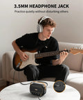 Person using Compact 5W Per Channel Guitar Amp, Portable Battery Powered Practice Speaker With Bluetooth for headphone practice