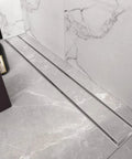 24 Inch Linear Shower Drain With Tile Insert Grate And Hair Strainer in brushed 304 stainless finish, mounted in tiled floor