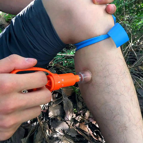 Using Snake Bite Kit And Bee Sting Kit For Outdoor First Aid Venom Extractor Suction Pump on leg with tourniquet