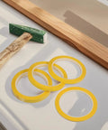 Four Pack Yellow Heat Resistant Paper Tape Featuring A Dang Tough Hold That Takes The Heat Without Breaking A Sweat on a workbench.