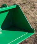Close-up of green 5 Foot Dirt Bucket Attachment For Tractors That Fits John Deere Hook And Pin Tractors on grassy field