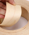 Hand holding Maple Wood Veneer Edge Banding, 2 Inch By 50 Foot Roll, Preglued Iron On Edgebanding With Hot Melt Adhesive