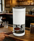 Bottomless Hassle Automatic Coffee Tamper Electric Espresso Press 58mm With Adjustable Pressure 5 To 30kg flat base in a cafe setting.