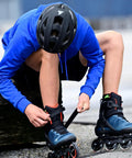 Person adjusting Macroblade 90 Fitness Inline Skates For Adults Unisex with blue and orange design and high cuff for support, size 38.