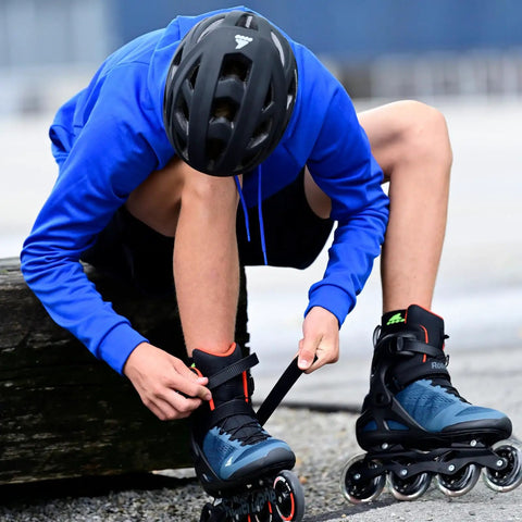 Person adjusting Macroblade 90 Fitness Inline Skates For Adults Unisex with blue and orange design and high cuff for support, size 38.