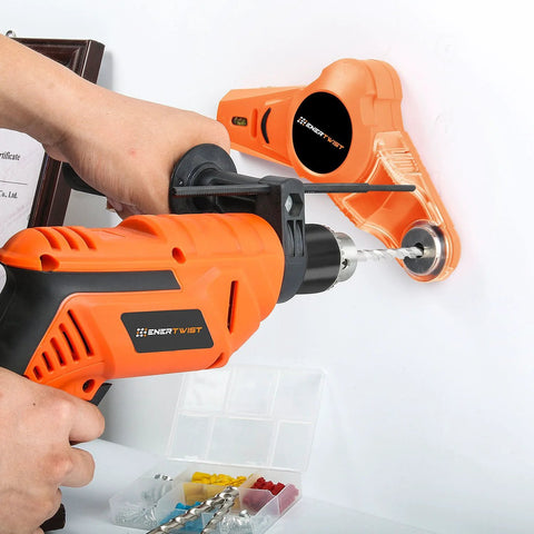 Side view of orange EnerTwist cordless drill with bit in chuck drilling into wall; carrying case with bits visible.