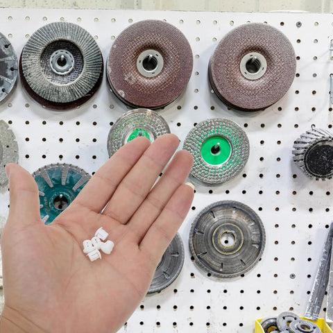White Plastic Hole Plugs 100 Pack Screw Hole Cover Caps For Cabinets And Furniture shown in hand, pegboard background
