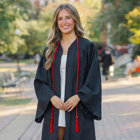 Graduate wearing black gown and a Red 68 Inch Graduation Honor Cord With Tassels At Both Ends, Durable Polyester Yarn, Knotted Ends.