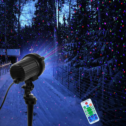Outdoor Laser Christmas Lights Projector With RGB Moving Firefly Effects illuminating a snowy path and trees with remote control visible.