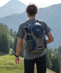 Person with Ultralight 30L Packable Hiking Backpack For Women And Men Foldable Travel Daypack in mountainous landscape