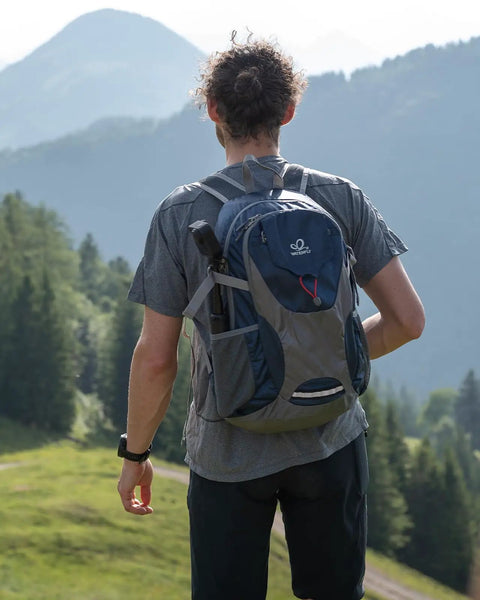 Person with Ultralight 30L Packable Hiking Backpack For Women And Men Foldable Travel Daypack in mountainous landscape