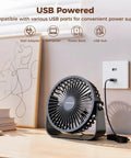 USB Desk Fan Portable Mini Personal Fan with 360 Degree Head on desk, plugged into USB wall adapter, black color.