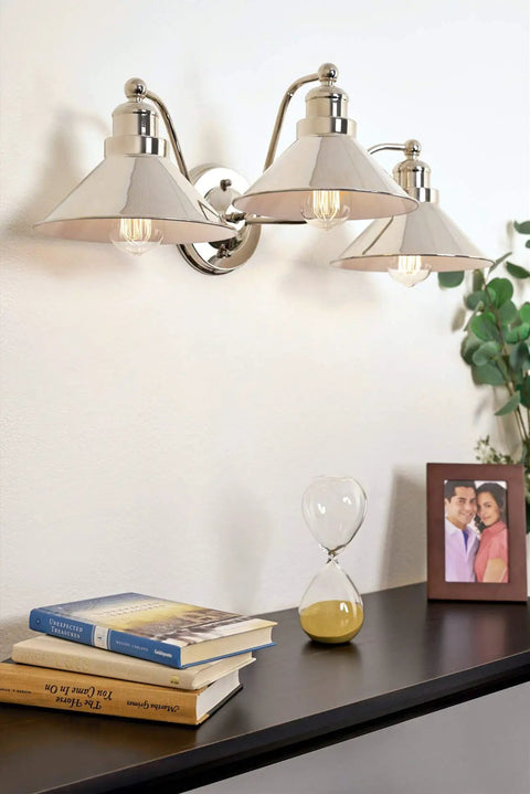 Welton 25.5 Inch Three Light Modern Farmhouse Vanity Light With Funnel Shades Gooseneck Industrial Wall Sconce on wall above books