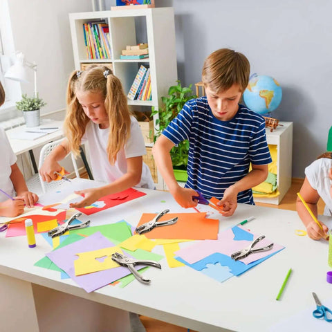 Children using 24 Pack Handheld One Hole Punches, No Fuss One Quarter Inch Six Millimeter Metal Paper Puncher For Tags, Tickets, Labels