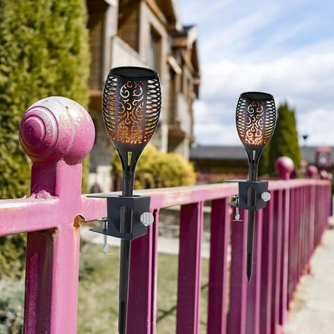Heavy Duty Deck Torch Clamp Set Black Metal Rail Mounts For Outdoor Torches Universal Porch Rail Clamp Accessory Weatherproof Galvanized Steel Anti Rust Two Pack Fits Railings And Poles For Easy Deck Lighting installed on pink railings.