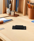 Hidden 5 Inch Black Concealed Wood Door Hinges for Secret Doors and Bookcases shown on a desk with stationery tools.
