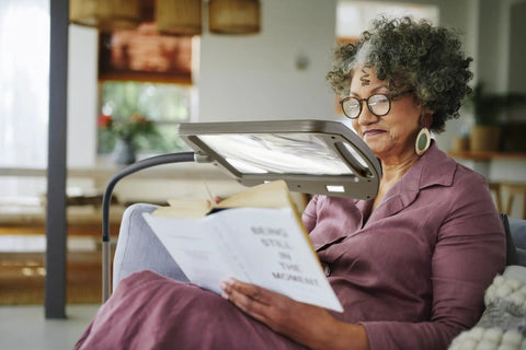 Woman reading under a Bronze Floor Magnifier Lamp With 8x10 Inch Shade 3x Magnification Built In LED Lighting Full Page View