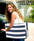 Woman carrying a striped Waterproof Sandproof Large Canvas Beach Tote with Zippered Wet Pocket, perfect for travel and beach.