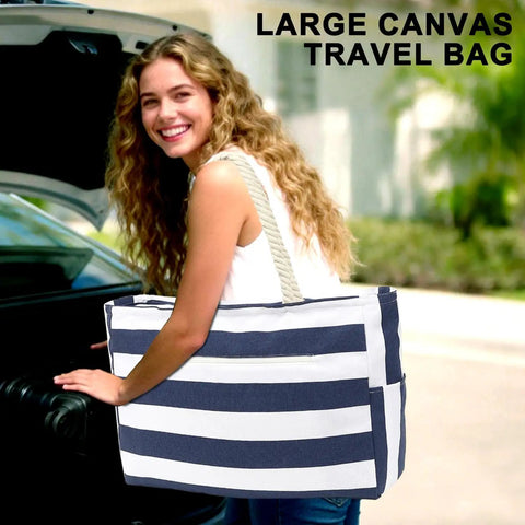 Woman carrying a striped Waterproof Sandproof Large Canvas Beach Tote with Zippered Wet Pocket, perfect for travel and beach.