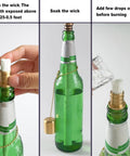 Outdoor Wine Bottle Torch Kit Two Pack With Long Life Wicks Brass Wick Holders And Caps in use with green glass bottle.