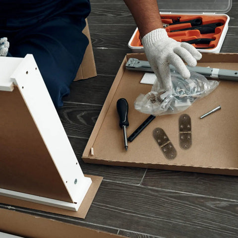 Person assembling furniture with tools and Four Pack 180 Degree Butterfly Cabinet Hinges With Round Edges Spring Loaded Folding Desk Flap Hinges For Furniture Doors And Packaging Boxes Built Tough Easy Flip Design Ideal For Cabinets Desks And Projects on a wooden floor.