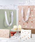 Grab And Go Medium Sized Gift Bag Set With Handles, 9 Inch, includes tissue paper, cards, and envelopes, displayed with cupcakes.
