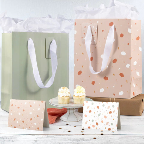Grab And Go Medium Sized Gift Bag Set With Handles, 9 Inch, includes tissue paper, cards, and envelopes, displayed with cupcakes.