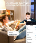 Couple using Alexa Compatible Smart Light Bulbs 100W Equivalent in living room, phone app controls lighting routine.