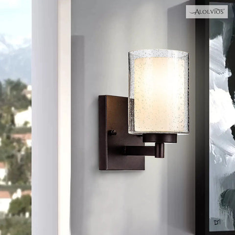 Pair Of Farmhouse Style Oil Rubbed Bronze Wall Sconces With Seeded Glass Shades on wall, featuring ambient lighting.