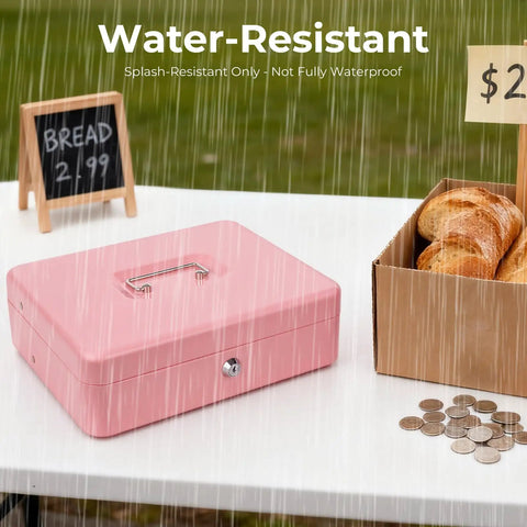 Pink Cash Box With Money Tray And Key Lock for cash till outdoors in rain at market with bread and coins visible nearby.