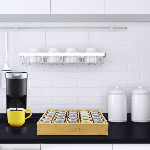 Bamboo Coffee Pod Organizer For Drawer Or Countertop Space Saver that holds 24 to 36 K cups on a kitchen counter next to a coffee maker.