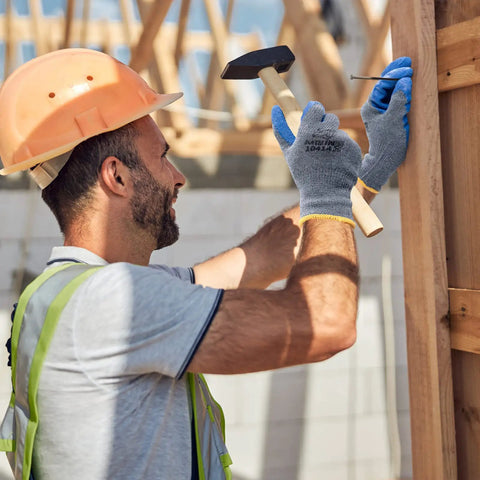 Construction worker using Six Pairs Latex Coated Palm Work Gloves With Seamless Knit Lining for superior grip while hammering a nail