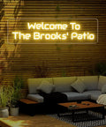 Custom Outdoor Neon Sign Waterproof LED Light Up Sign For Backyard Patio Pool Garden Wedding And Party Use Personalize Your Text With IP67 Power Supply For Rain Or Shine, installed on wooden fence above outdoor seating area.