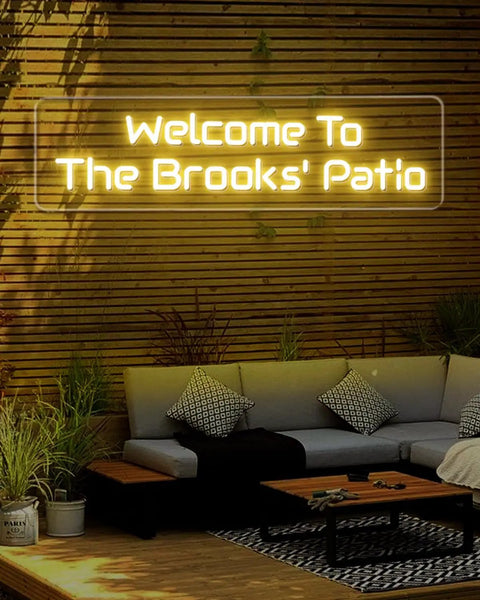 Custom Outdoor Neon Sign Waterproof LED Light Up Sign For Backyard Patio Pool Garden Wedding And Party Use Personalize Your Text With IP67 Power Supply For Rain Or Shine, installed on wooden fence above outdoor seating area.