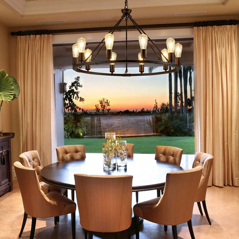 Black Farmhouse Wagon Wheel Chandelier With 10 Lights 31.5 Inch in dining room over round table at sunset
