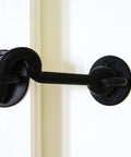 Sliding Door Privacy Hook 4 Inch Matte Black With Mounting Hardware Included Steel Construction Keeps Your Space Private And Quiet No Fuss For Indoor Barn Doors Perfect Accessory For Designer Classic And Builder Kits installed on a white door.