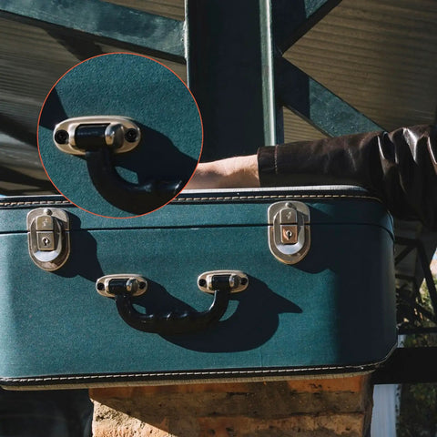 Close-up of a teal suitcase handle and locks with a focus on metal fasteners