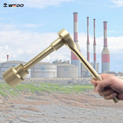 Non Sparking Three Quarters Inch Socket Set tool held in hand with industrial plant in background, aluminum bronze.
