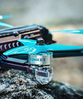 Side view of a quadcopter with blue propellers and a Four Pack 2207 1960KV FPV Brushless Motors For 5 Inch Freestyle Racing Drones.