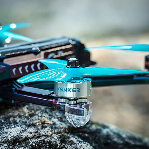 Side view of a quadcopter with blue propellers and a Four Pack 2207 1960KV FPV Brushless Motors For 5 Inch Freestyle Racing Drones.