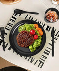 Black plate with steak, lettuce, and tomatoes on a patterned mat; part of Built Tough 36 Piece Wheat Straw Dinnerware Set For 6 No Fuss Unbreakable Bowls Plates And Cups Dishware Safe For Dishwasher And Microwave Ideal For Outdoor Camping Black
