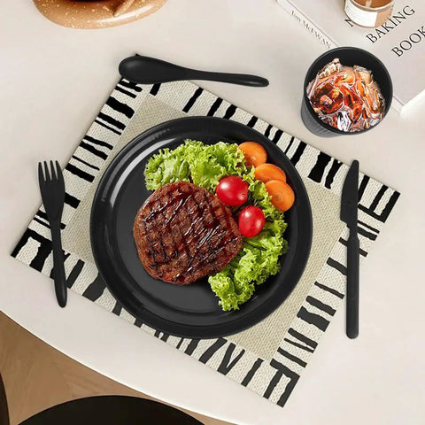 Black plate with steak, lettuce, and tomatoes on a patterned mat; part of Built Tough 36 Piece Wheat Straw Dinnerware Set For 6 No Fuss Unbreakable Bowls Plates And Cups Dishware Safe For Dishwasher And Microwave Ideal For Outdoor Camping Black