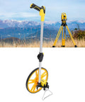 Dead On Accurate Mechanical Distance Measuring Wheel With Hella Tough Aluminum Alloy Build And Integrated Carry Handle For No Fuss Industrial Surveys Or Home Diy Projects Includes Top Shelf Travel Carrier positioned against mountainous landscape.